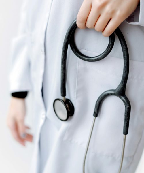 Close-up of a doctor holding a stethoscope, showcasing professional medical attire.